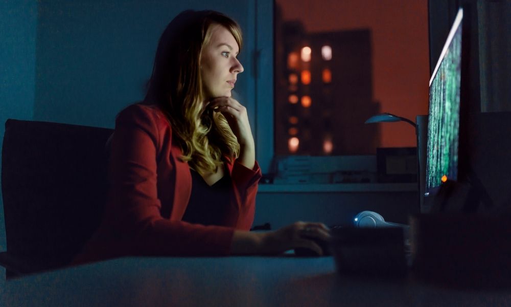 Cybersecurity professional monitoring computer systems at night