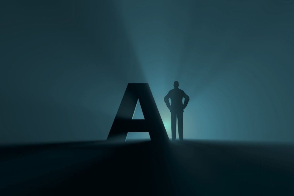 Silhouette of a person standing beside a large AI letter in a dark environment.